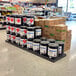 A black plastic Benchmaster platform panel on a grocery store aisle counter.