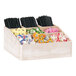 A Cal-Mil white-washed pine wood condiment organizer holding condiments and straws.