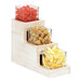 A Cal-Mil Newport white-washed wood condiment organizer with three glass jars filled with lemon slices, green olives, and fruit.