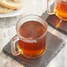 A pair of glass mugs of Twinings Chai Latte on a stone coaster.