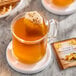 A glass mug of Twinings Orange & Cinnamon Spice Herbal Tea with a tea bag in it.