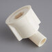 A close up of a white plastic Main Street Equipment evaporator drain fitting with a small hole in it.