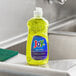 A bottle of JoySuds Joy Ultra lemon scented dishwashing liquid on a counter in a professional kitchen.