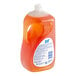 A bottle of JoySuds Orange Scented dishwashing liquid with an orange label.