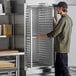 A man assembling a Regency end load sheet pan rack in a professional kitchen.