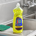 A bottle of Joy lemon scented dishwashing liquid on a sink.