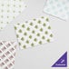 A group of white Choice customizable interfolded bakery tissue sheets with blue designs on them.