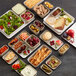 An American Metalcraft cream melamine square plate with a tray of food, bowls of salad, fruit, and olives on a table.