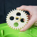 A hand holding a white Garde gear.