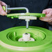 A person holding a green Garde large gear with a metal handle.