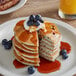 A stack of Krusteaz blueberry pancakes with syrup on top.