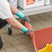 A person wearing Ansell AlphaTec nitrile gloves cleaning a floor.