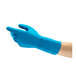 A blue natural latex rubber glove with a fish scale grip, shown on a person's hand.