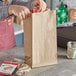 A man putting a can into a Choice Natural Kraft Paper bag.