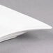A CAC rectangular bone white porcelain platter with curved edges on a gray surface.