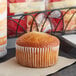 An Otis Spunkmeyer cheese streusel muffin on a tray in a bakery display.