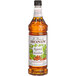 A close up of a Monin Roasted Hazelnut Flavoring Syrup bottle with a label.