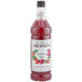 A close up of a Monin bottle of strawberry rose syrup.