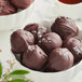 A bowl of chocolate truffles on a counter.