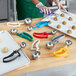 A woman using a red EZ Grip Squeeze Handle Disher to scoop cookies.