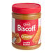 A jar of Lotus Biscoff creamy cookie butter on a table with a knife.