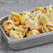 A silver tray of Amoy Royal Dragon Crab Rangoon on a school kitchen counter.