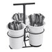 A white container with black wire around 3 white cylinders holding silverware.