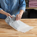 A woman holding a white customizable paper shipping bag.