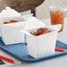 A tray with two Emperor's Select white takeout containers filled with food.