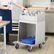 A person holding a ServIt stainless steel tray with flatware cylinders on a tray.