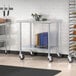 A Steelton stainless steel work table with undershelf and casters in a school kitchen.
