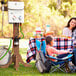 A woman and girl sitting at a table with an Eccotemp portable outdoor water heater.