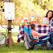 A man and woman using an Eccotemp outdoor water heater at a picnic table.