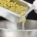 A metal tray with Sweet Peas being poured into it.