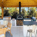 A Chicago Brick Oven black wood-fired countertop pizza oven on an outdoor patio.