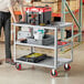 A man standing next to a Lavex utility cart with a black tool box on it.