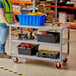 A man standing next to a Lavex steel utility cart with red and black tool boxes on it.