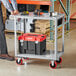 A man standing next to a Lavex steel utility cart with tools on it.