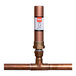 A copper pipe with a white label on an Oatey Quiet Pipes D Straight Hammer Arrestor.