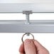 A hand adjusting the height of a Luxor double-sided whiteboard stand.