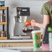 A digital automatic coffee maker with a single decanter warmer and a glass coffee decanter.
