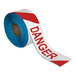 A roll of red and white striped "Danger" safety tape.