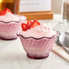 Two Choice pink plastic dessert dishes with pink dessert and strawberries.