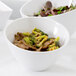 An American Metalcraft white melamine serving bowl filled with beef and broccoli.