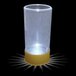 A clear plastic shotgun shell shot cup with a white LED light inside.