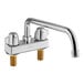 A chrome deck-mount faucet with two gold handles and a 12" swing spout.