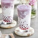 Two glasses of purple Ube Taro drinks on a marble table.