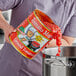 A person pouring Stanislaus Tomato Magic Ground Peeled Tomatoes into a pot.