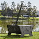 A Nuke BBQ Huapi wood fire pit and grill with a metal object on top of the grill.