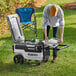 A woman opens a white Igloo Trailmate Journey cooler on the grass.